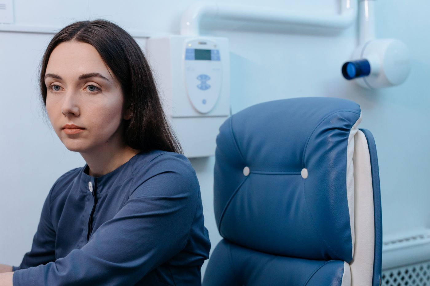 A patient waiting alone in a clinic chair, longer than expected.