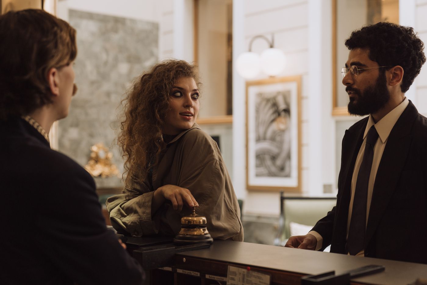 A guest and receptionist mid-conversation at checkout.