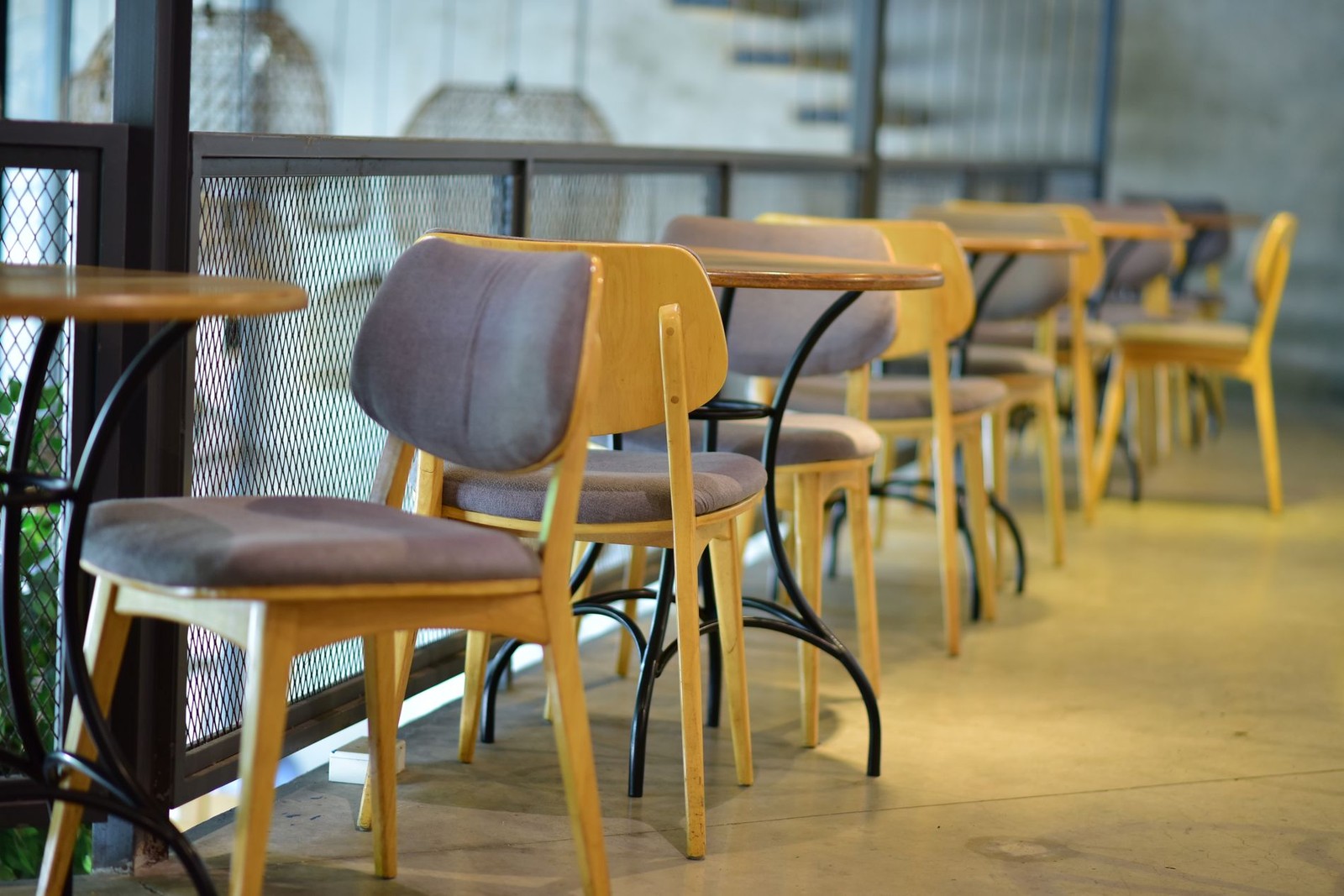 A row of café chairs and tables left empty after service.